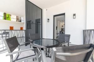 uma varanda com uma mesa de vidro e cadeiras em Stone house em Baška Voda