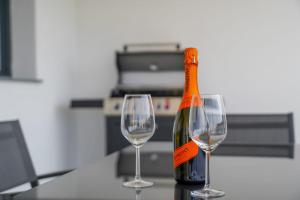 uma garrafa de vinho sentada ao lado de dois copos de vinho em Stone house em Baška Voda