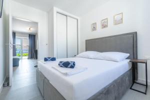 um quarto com uma grande cama branca e uma grande janela em Stone house em Baška Voda