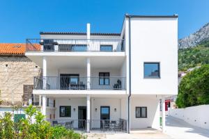 um edifício de apartamentos branco com uma varanda em Stone house em Baška Voda