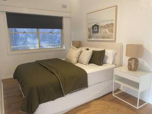 1 dormitorio con cama y ventana en Terrigal Coastal Casa, en Wamberal