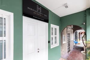 a hallway with a white door and green walls at NEWLY REFURBISHED - Heritage Collection on Ann Siang in Singapore