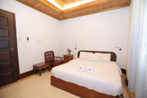 a bedroom with a bed with two swans on it at Villa KiengKham晶康民宿 in Luang Prabang