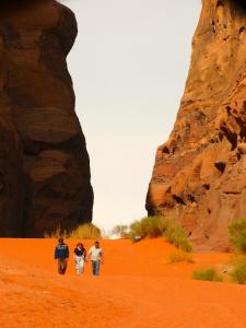 three people walking in the desert near a rock formation at Wadi rum view camp in Wadi Rum