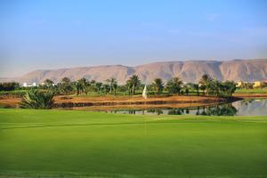 a view of a golf course with palm trees and water at Steigenberger Golf Resort El Gouna in Hurghada