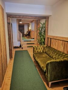 - un salon avec un canapé et un tapis vert dans l'établissement Gasthaus Auwirt, à Fieberbrunn