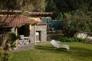 een tuin met een witte stoel in het gras bij Casas Maravilha by Madeira Sun Travel in Calheta