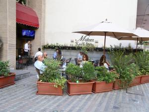 een groep mensen in een restaurant met planten bij Midtown Hotel & Suites in Beiroet