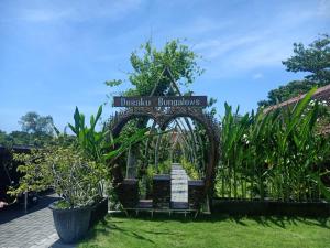 um sinal para os burumantes dassociation num jardim em Desaku Bungalows em Canggu