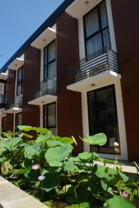 Um edifício com um lago de lótus à frente. em ValStar Hotel Canggu em Canggu