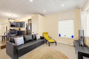 a living room with a black couch and a yellow chair at Black Pearl in Rutland