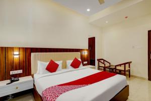 1 dormitorio con 1 cama grande con almohadas rojas en Hotel O SAI GRAND LUXURY ROOMS, en Tirupati