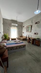 a bedroom with a large bed and a table at Bali Bobo Hostel in Jimbaran