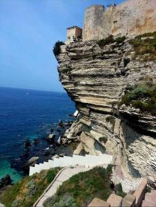 een gebouw op een klif naast de oceaan bij Appartement Kallisté, Logements avec vue citadelle de Bonifacio in Bonifacio