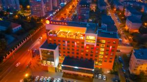 une vue aérienne sur un bâtiment la nuit dans l'établissement Ramada by Wyndham Oradea, à Oradea