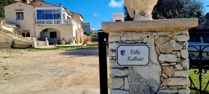 een stenen muur met een bord voor een huis bij Appartement Kallisté, Logements avec vue citadelle de Bonifacio in Bonifacio