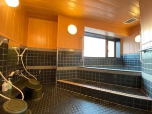 baño con aseo, bañera y ventana en Towada City Hotel - Vacation STAY 85224v, en Towada