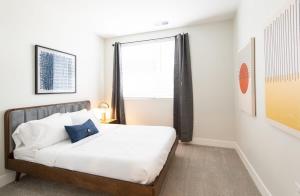 1 dormitorio con cama y ventana grande en Cozysuites l Luxe 2BR in Downtown Cincinnati, en Cincinnati