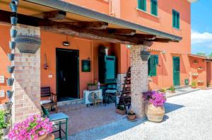 een oranje huis met een patio met paarse bloemen bij La locanda di Andrea il pescatore in Borgo Montenero