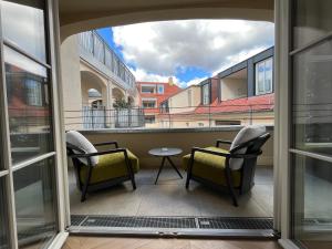 een balkon met 2 stoelen en een tafel bij Luxury Home / 2-Raum-Apartment an der Frauenkirche in Dresden