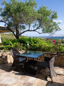 una mesa y sillas con un árbol y flores en Villa Minda Lodge & View, en San Teodoro