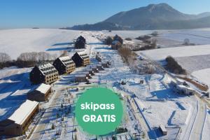 uma vista aérea de uma cidade coberta de neve com uma cobertura verde em Demänová Rezort em Liptovský Mikuláš