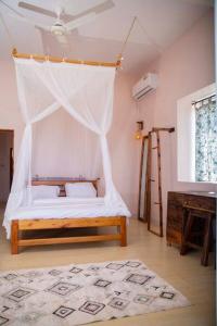 a bedroom with a bed with a mosquito net at Kumekucha Ocean View in Dar es Salaam