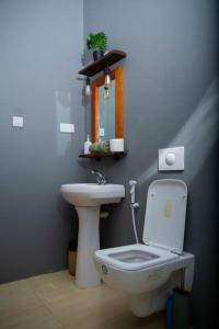 a bathroom with a white toilet and a sink at Kumekucha Ocean View in Dar es Salaam