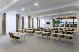 una sala conferenze con tavoli e sedie in una stanza di Eden Grand Resort a Predeal