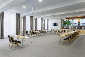 una sala conferenze con tavoli e sedie in una stanza di Eden Grand Resort a Predeal