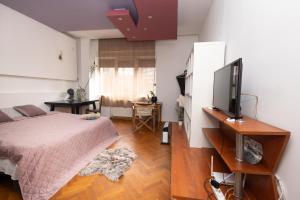 Schlafzimmer mit einem Bett und einem Flachbild-TV in der Unterkunft Shared Retro Vintage Luxury Apartment in Bukarest