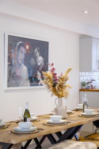 een eettafel met een schilderij aan de muur bij Luxury 5 Bedroom House By The Sea in Brighton & Hove