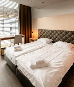 a bedroom with a large bed with white towels on it at Los Lorentes Apartments Bern Airport in Belp