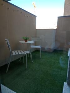 a patio with a table and chairs on a balcony at Apartamento Servet, parking gratuito in Bormujos