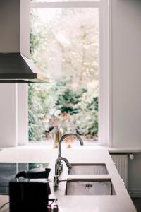 a kitchen with a sink and a window at Luxious Apartment Wilhelmina in Tilburg