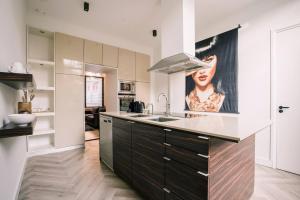 a kitchen with a sink and a large painting on the wall at Luxious Apartment Wilhelmina in Tilburg