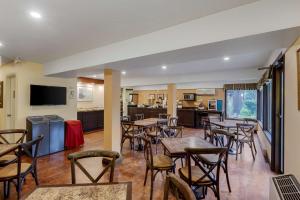 a restaurant with tables and chairs and a kitchen at Best Western Plus Otonabee Inn in Peterborough