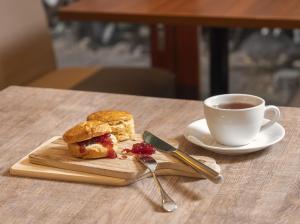 ein Sandwich auf einem Schneidebrett neben einer Tasse Kaffee in der Unterkunft Kobe Tor Road Hotel Sanraku in Kōbe