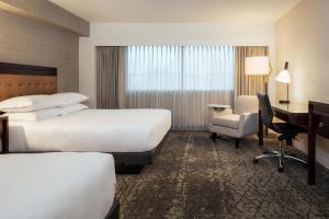 um quarto de hotel com duas camas e uma secretária em Sheraton Detroit Metro Airport em Romulus