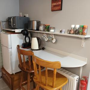 een keuken met een aanrecht met 2 stoelen en een koelkast bij Kates Place Studio 1 in Donegal