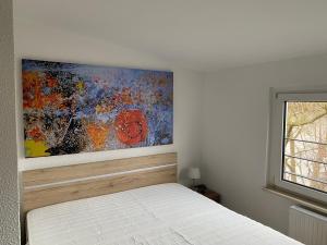 um quarto com uma cama com um quadro na parede em Haus Heiken Apartment Sonnenblume em Altenburg