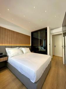 een slaapkamer met een groot bed met witte lakens bij BlueMotion - CruiseHub 1B in Piraeus