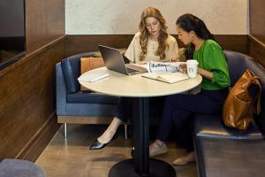 dos mujeres sentadas en una mesa con un portátil en Courtyard by Marriott Seattle SeaTac Airport, en Seattle