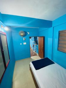 a blue bedroom with a bed and a blue wall at VEE CEE TOWER FURNISHED APPARTMENT in Sultan Bathery