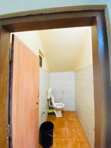 a bathroom with a toilet in a room with a door at VEE CEE TOWER FURNISHED APPARTMENT in Sultan Bathery