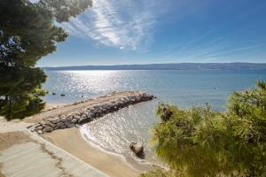 una playa con una pared de roca en el agua en Rogač Rooms & Restaurant, en Omiš