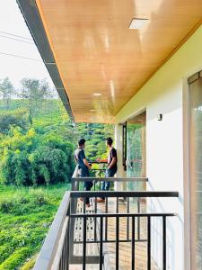 2 personnes debout sur le balcon d'une maison dans l'établissement Green view suits, à Vythiri