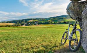 ein Fahrrad, das neben einem Felsen auf einem Feld parkt in der Unterkunft Gaestehaus Hofer in Bad Birnbach