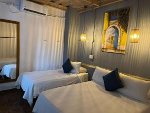 een hotelkamer met 2 bedden en een spiegel bij Maloka Boutique Hostel in Cartagena