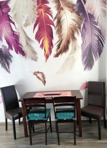 a table and chairs with feathers on a wall at Ferienwohnung Auszeit in Chemnitz